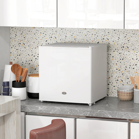 The white mini freezer sits on a speckled worktop in a kitchen setting