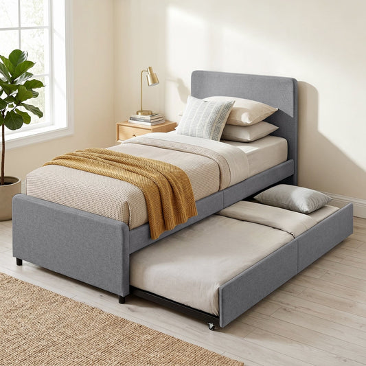 The upholstered pull out bed with trundle is set up in a bedroom with bedding
