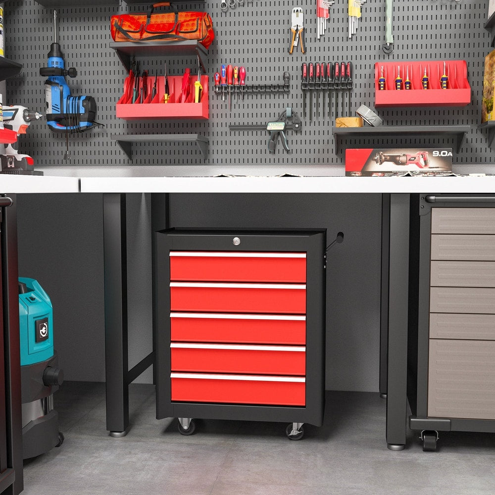 The tool chest placed under a workbench in a garage workshop setting with various tools above