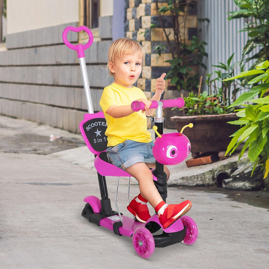 A young child sits on the pink kids scooter with a parent pushing from behind