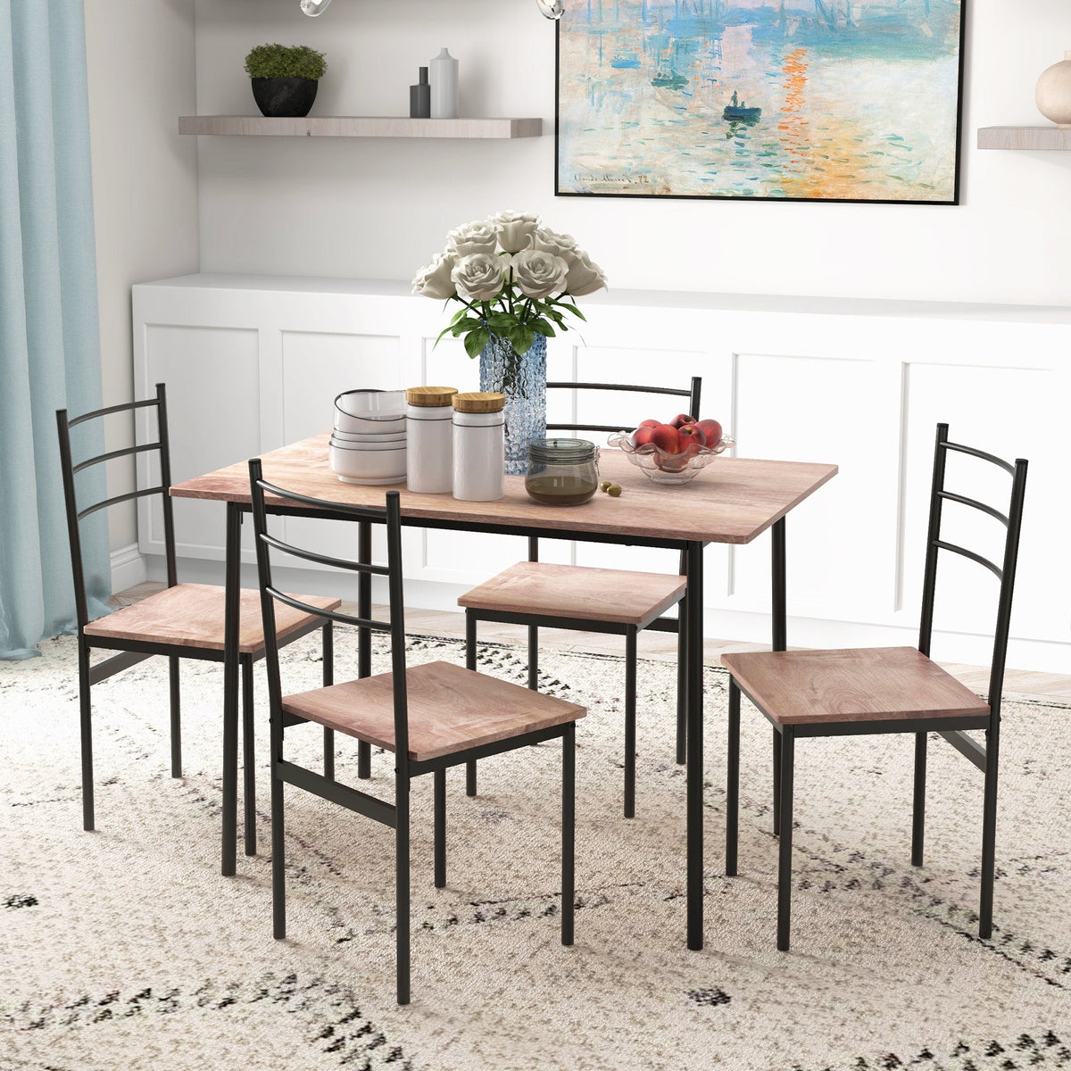 The dining set in a room setting with a rug and wall art