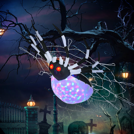 The hanging giant spider is displayed outdoors at night, draped in a spooky garden setting