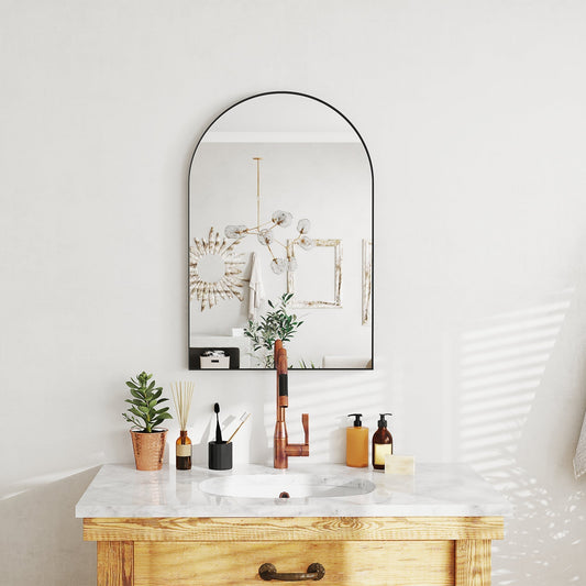 The arched bathroom mirror above a vanity unit with a sink and tap