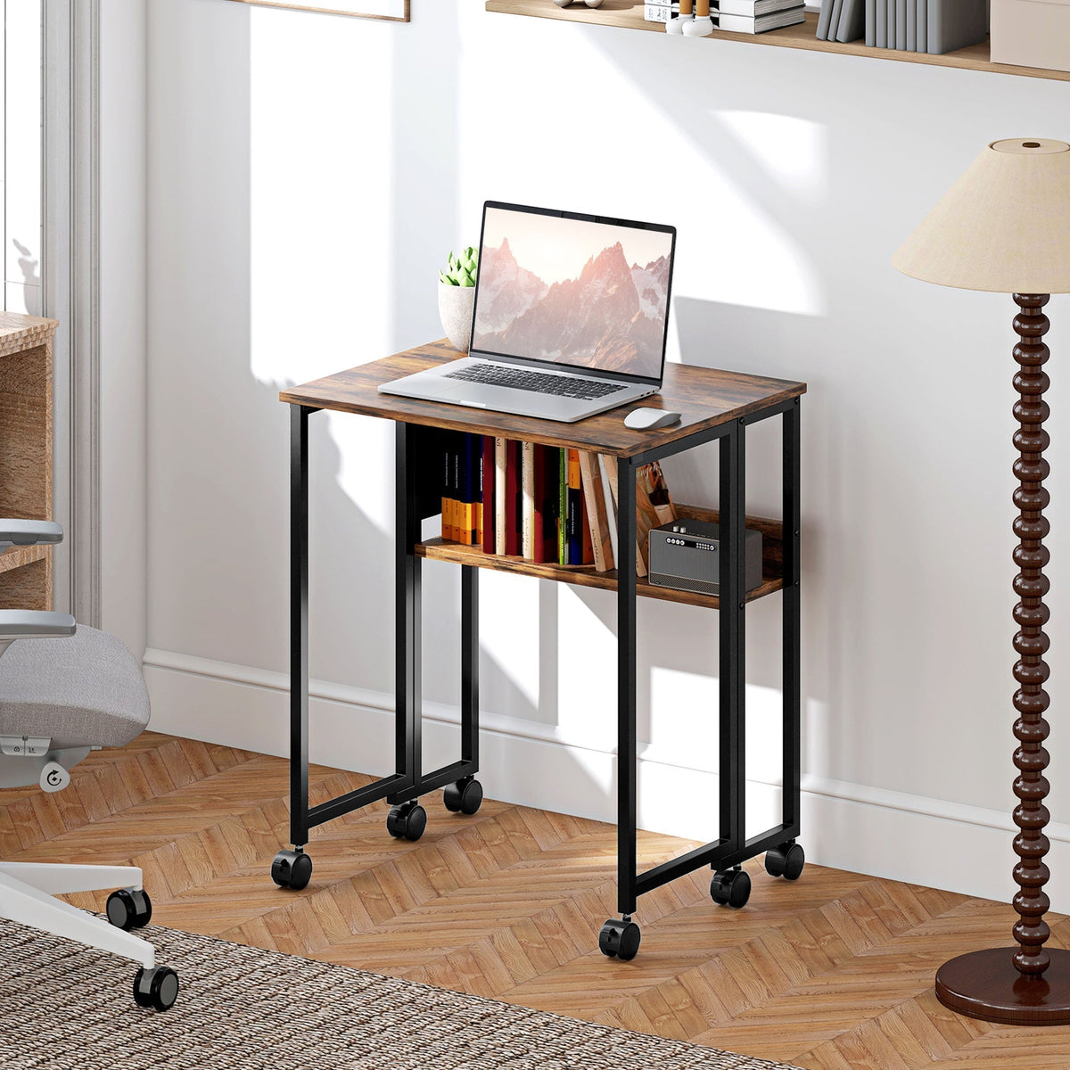 The office desk set up in a living room with a laptop and books on the shelves