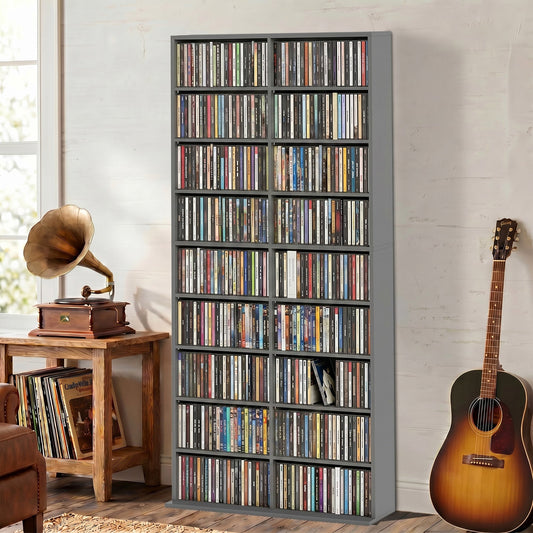 The grey media storage unit filled with CDs and DVDs in a room with a record player and guitar