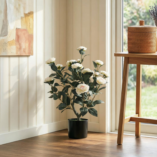 The artificial plant placed in the corner of a bright room next to a wooden side table