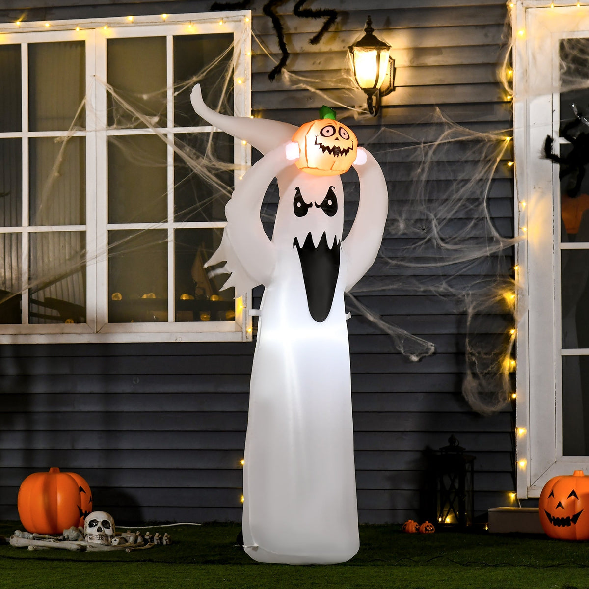 The Halloween inflatable decoration is shown outdoors at night, lit up with other decorations