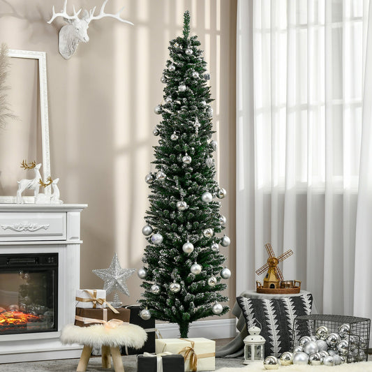 The pencil christmas tree decorated with silver baubles in a cosy living room with a fireplace