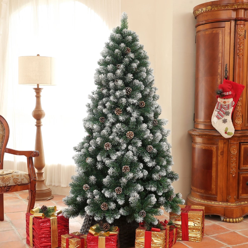 The artificial Christmas tree decorated with gifts and a lamp in a room