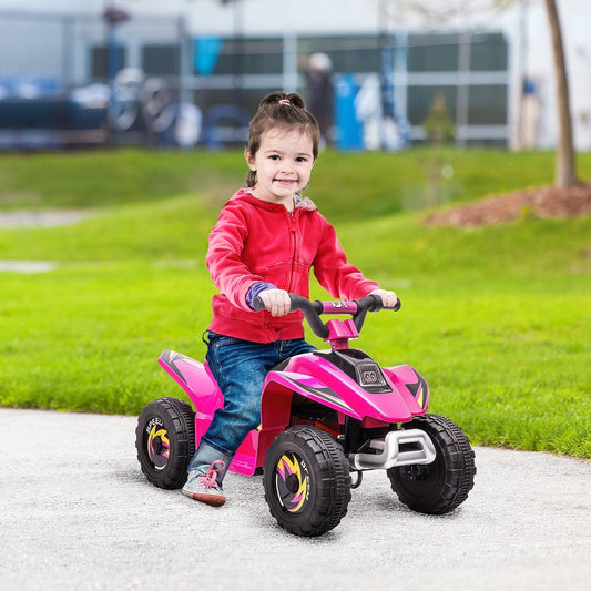 A young girl happily rides the pink electric quad bike toy in a park setting