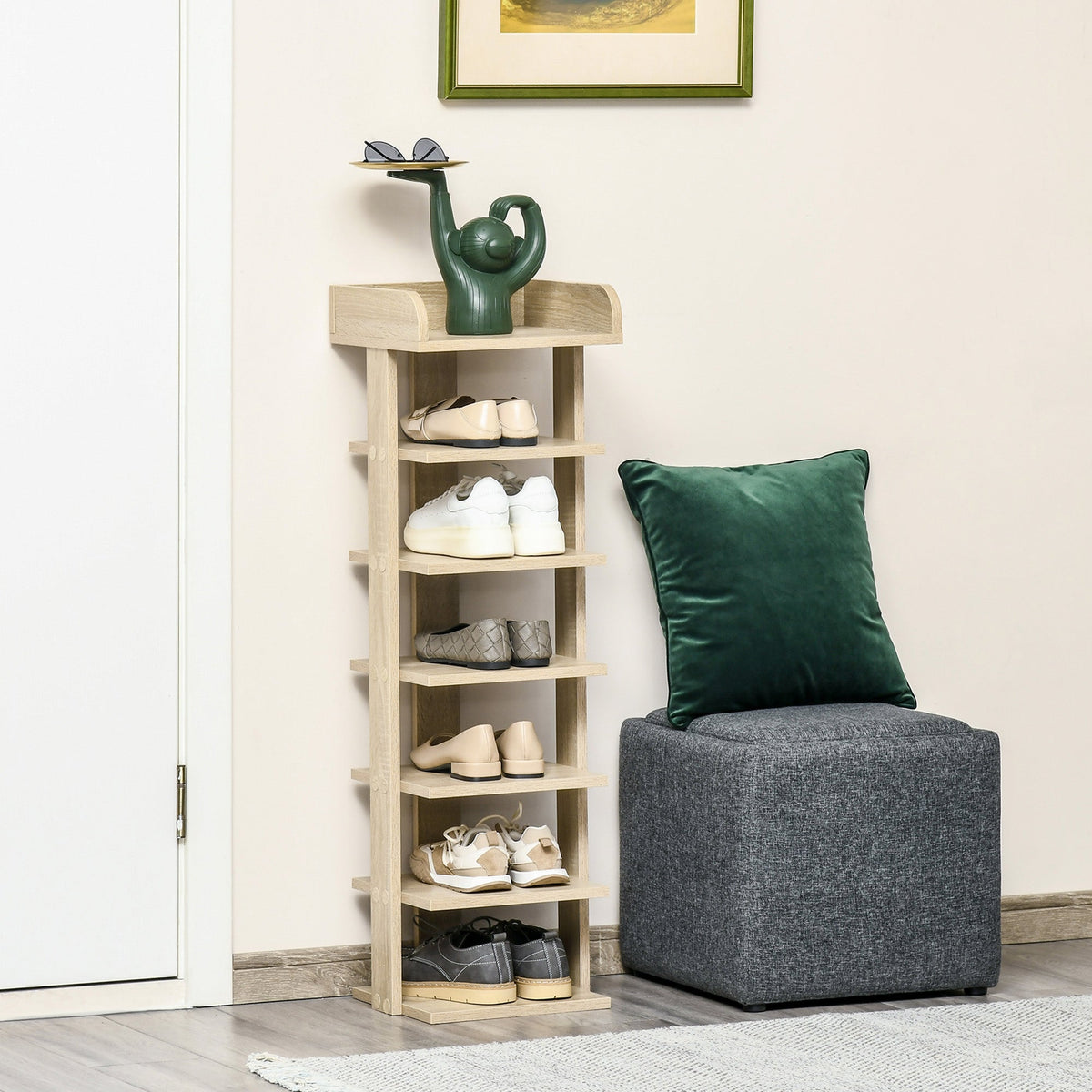 The tall shoe storage unit is shown in a hallway with shoes on its shelves and a cushion nearby