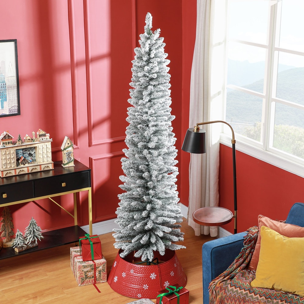 The pencil Christmas tree decorated in a living room with presents underneath and a red tree skirt