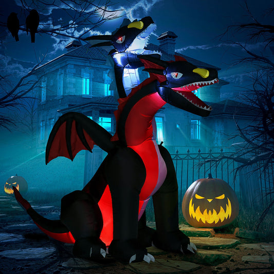 The two headed inflatable dragon decoration in a garden at night with a pumpkin