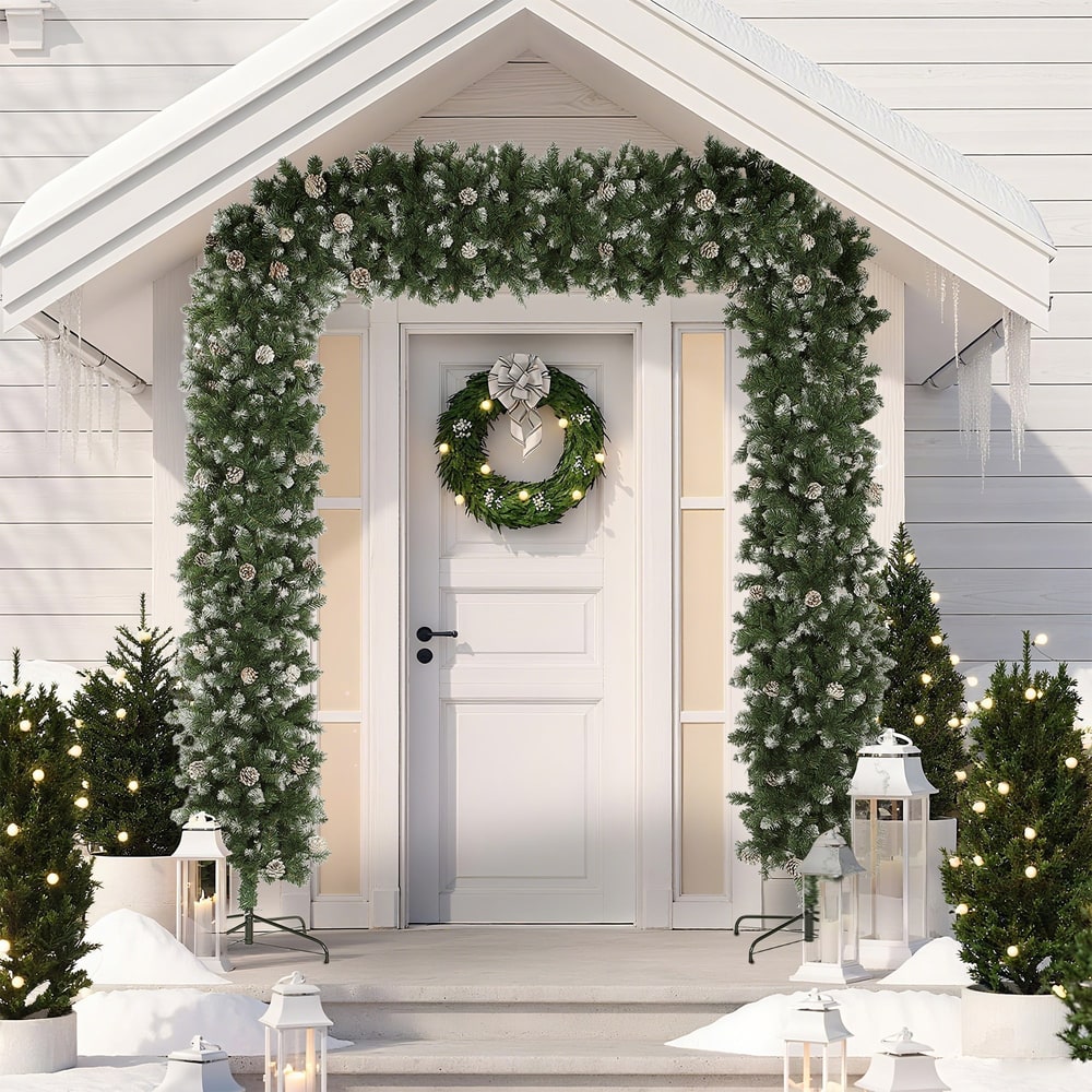 The snow frosted Christmas tree arch decorated over a doorway with a wreath