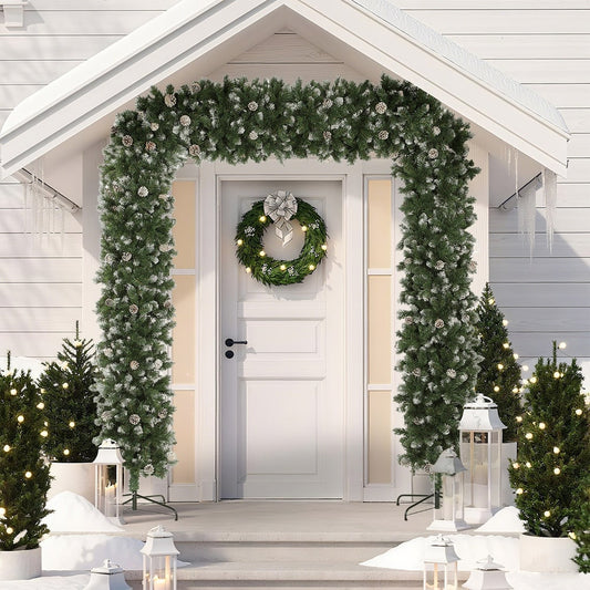 The snow frosted Christmas tree arch decorated over a doorway with a wreath