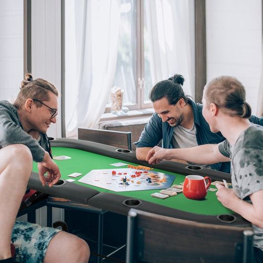 This oval card game table is set up for a poker night with four friends playing a board game