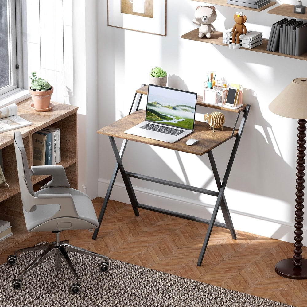 The folding computer desk set up in a home office with a laptop and chair