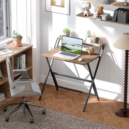 The folding computer desk set up in a home office with a laptop and chair