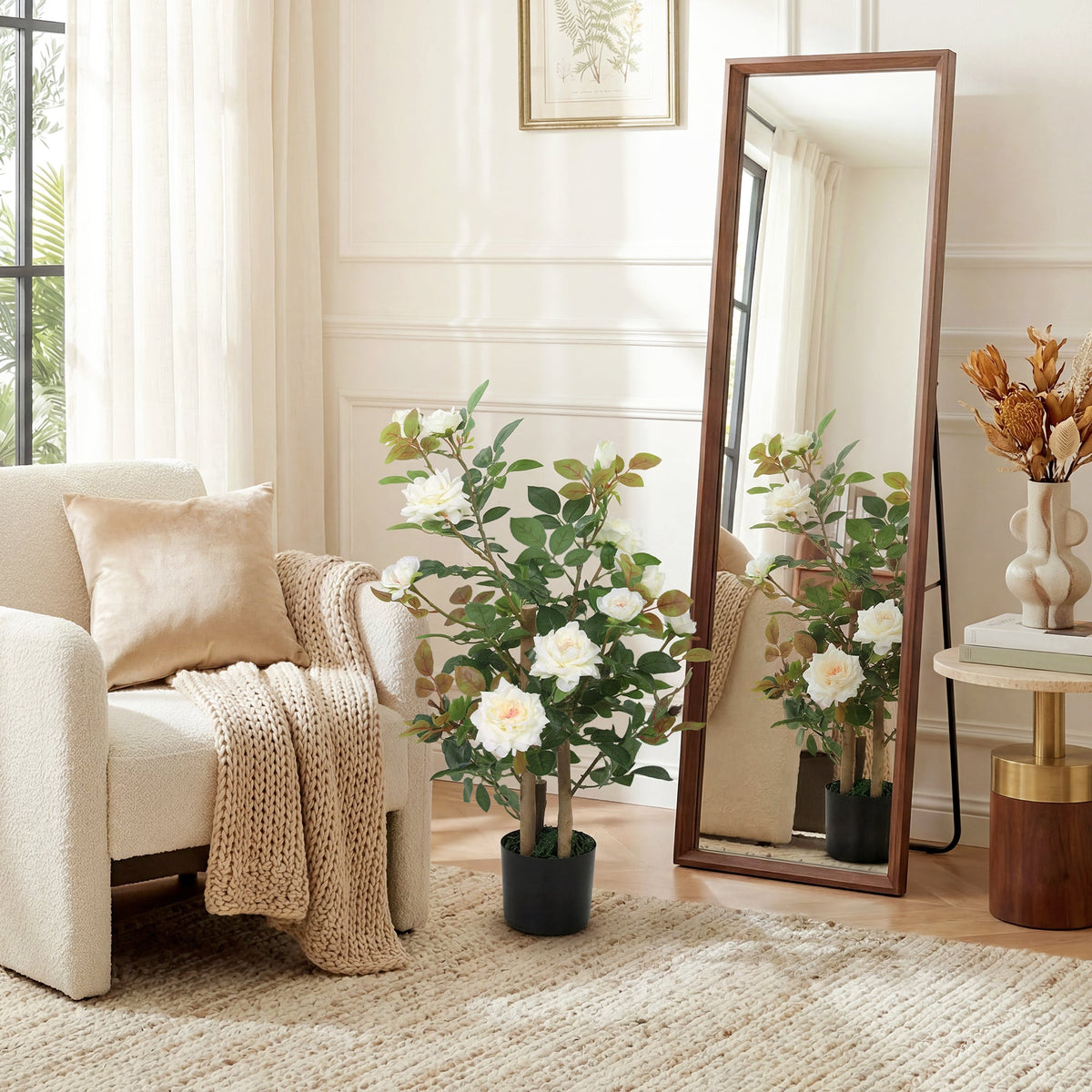 The artificial plant standing in a bright living room next to a tall wooden floor mirror