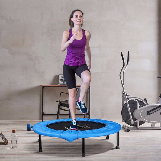 A woman exercising on the mini fitness trampoline in a room with gym equipment