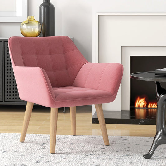 The pink armchair placed in a cosy living room setting next to a fireplace