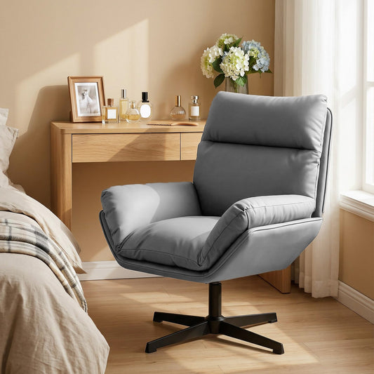 Dark grey armchair in a bedroom setting next to a bed and dressing table