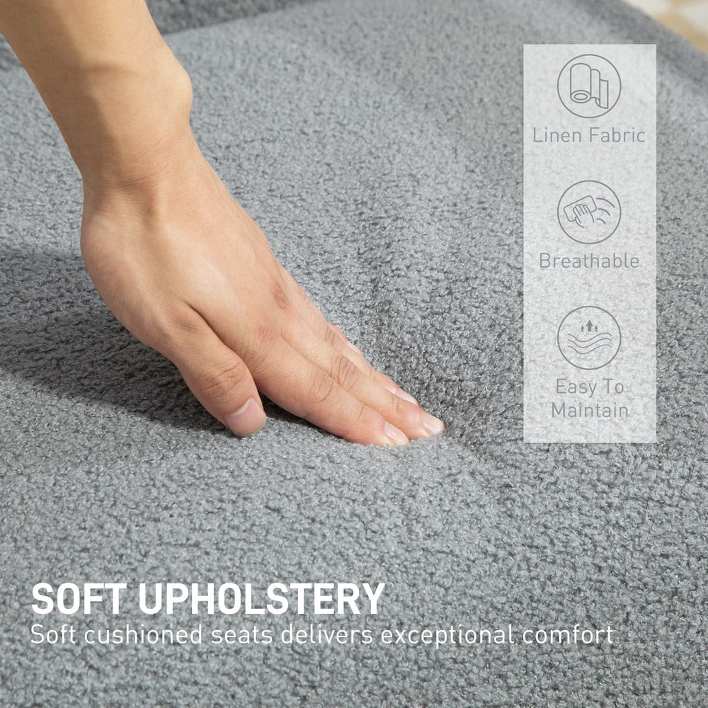 A hand touching the soft grey textured fabric of the armchair seat with feature icons