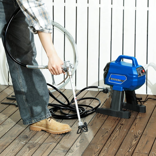 Person using the airless paint sprayer to paint a wooden deck