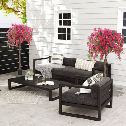 Two artificial blossom trees with red flowers decorating a patio set on a terrace