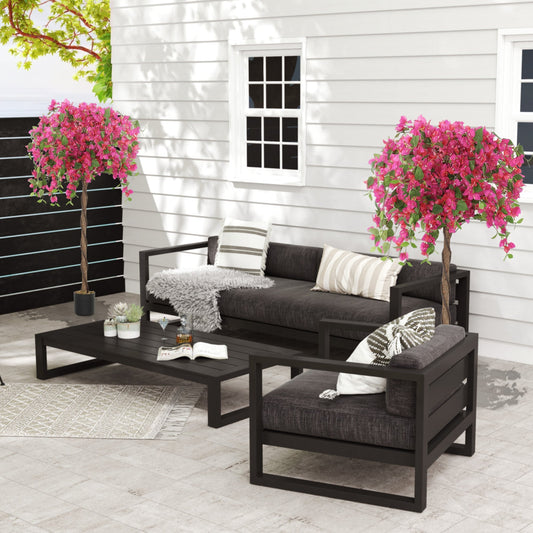 Two artificial blossom trees with red flowers decorating a patio set on a terrace