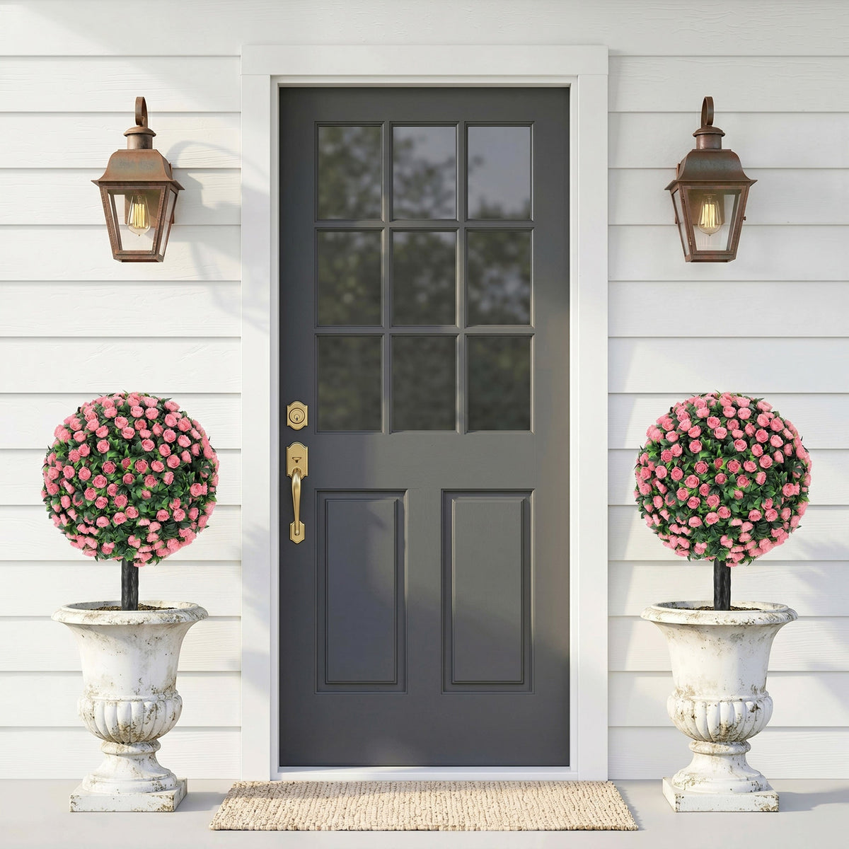The artificial plants placed in decorative stone urns on either side of a grey front entrance door
