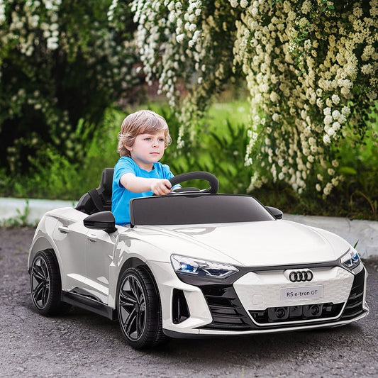 The electric ride-on car being driven by a young child on a paved path outdoors