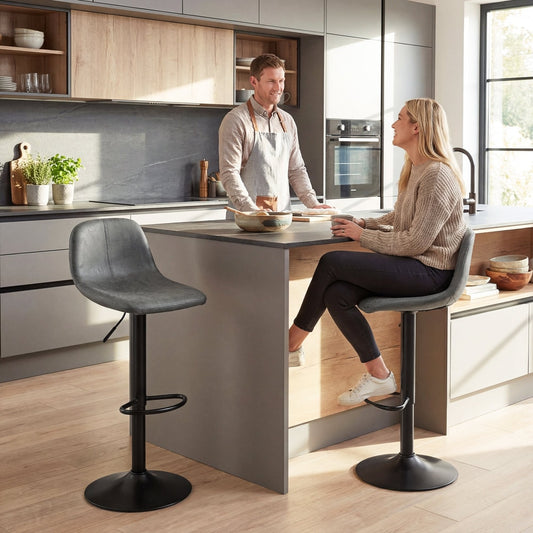 Two grey barstools in a modern kitchen setting with a couple interacting at the island