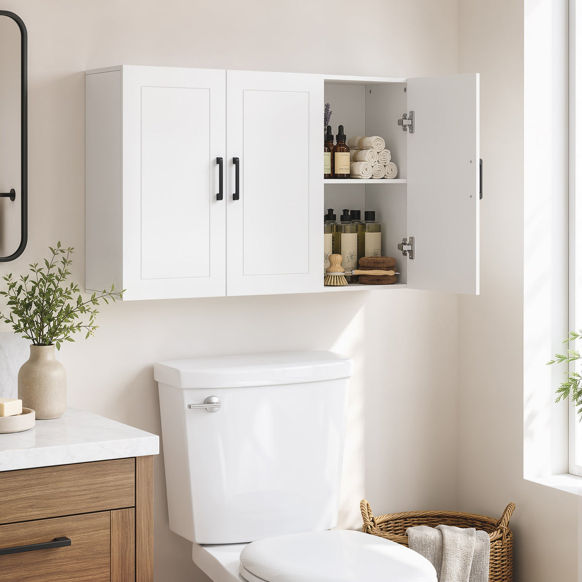 The bathroom cabinet mounted above a toilet, with one door open showing towels and bottles