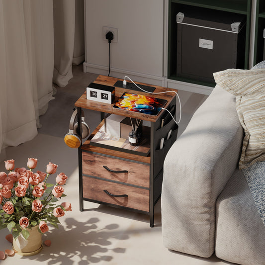 Bedside table with charging station in a living room next to a sofa and flowers