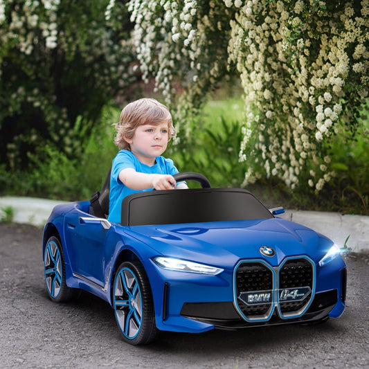 A young boy drives the blue kids electric ride-on car down a paved path lined with trees