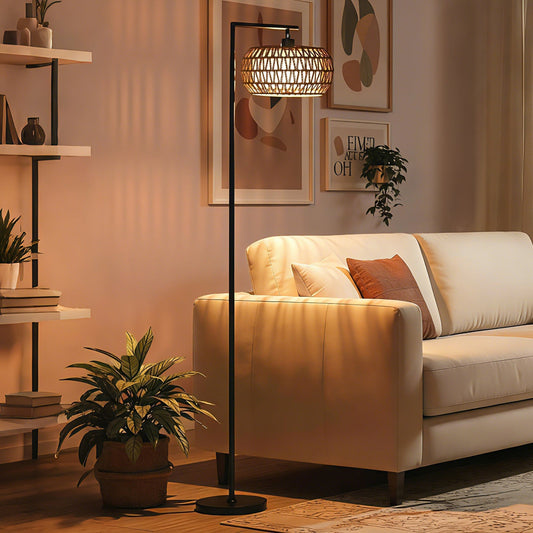 The black boho floor lamp in a living room next to a sofa and plants