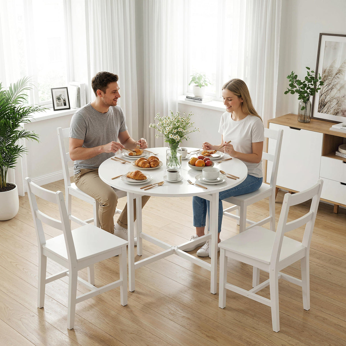 A white drop leaf dining table set up for two people eating breakfast in a bright kitchen