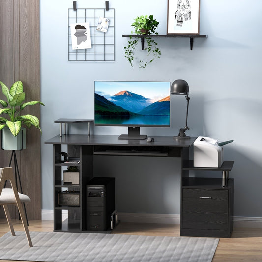 The office desk set up in a home study with a computer monitor, printer and desk lamp