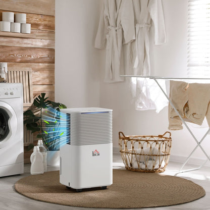 The portable quiet dehumidifier in a laundry room next to a washing machine and clothes drying rack