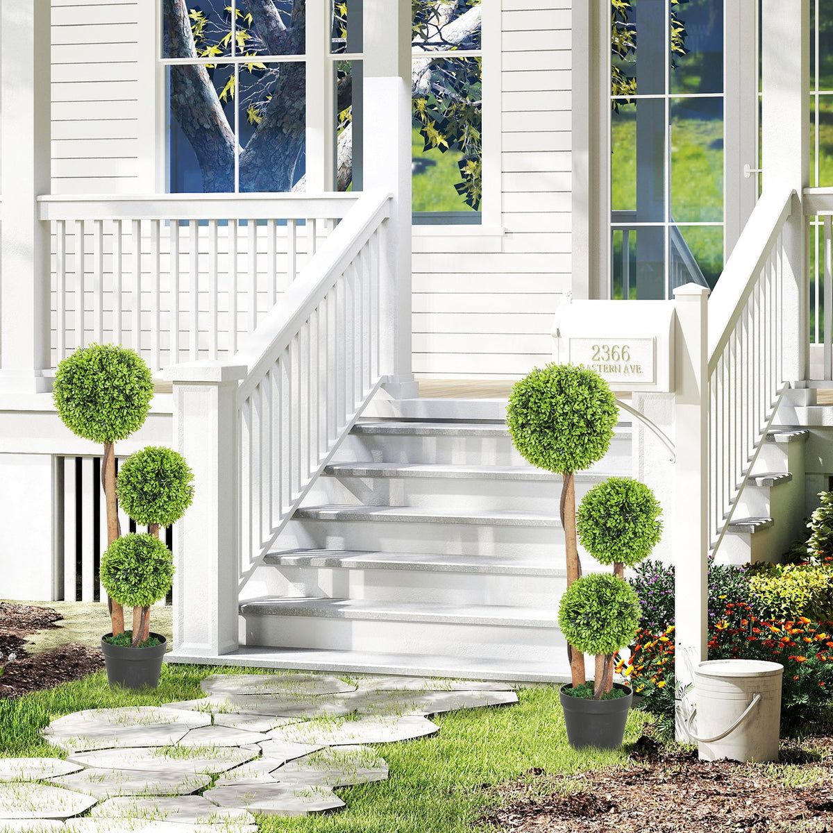 The artificial plants placed on either side of a garden path leading to a house