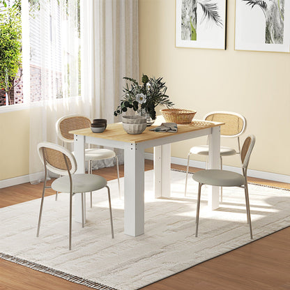 The dining table set in a bright room with four chairs and decorative items on top