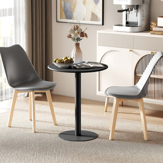 A round black dining table with two grey chairs in a modern room setting