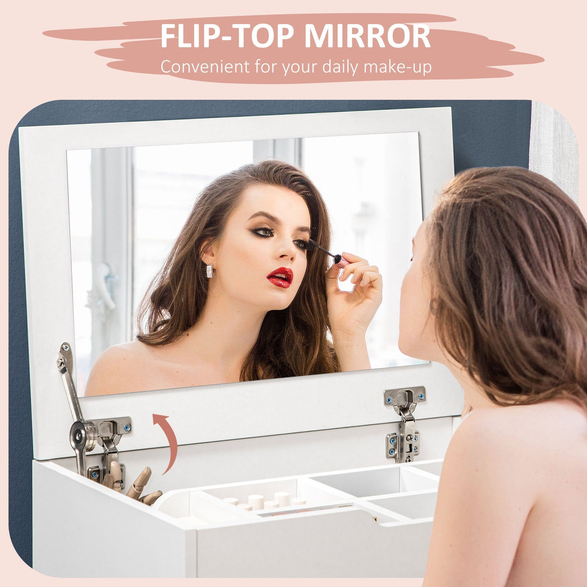 A woman applies makeup using the flip-top mirror of the white vanity table