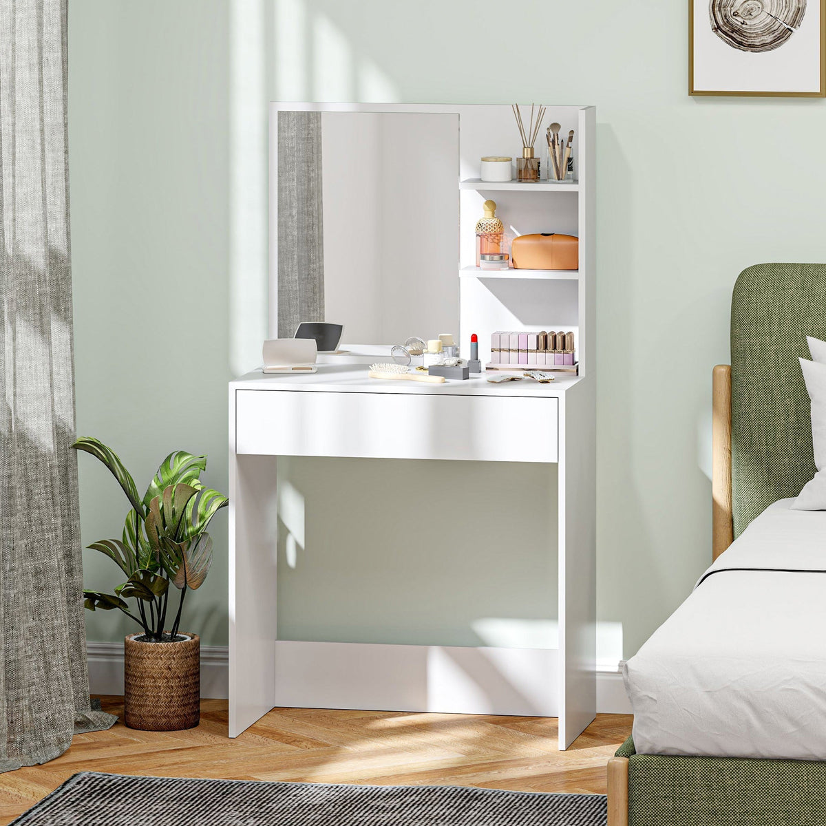 The dressing table placed in a bedroom next to a green bed with beauty products on the surface