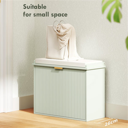 The shoe storage unit with the door closed and a bag placed on the padded seat