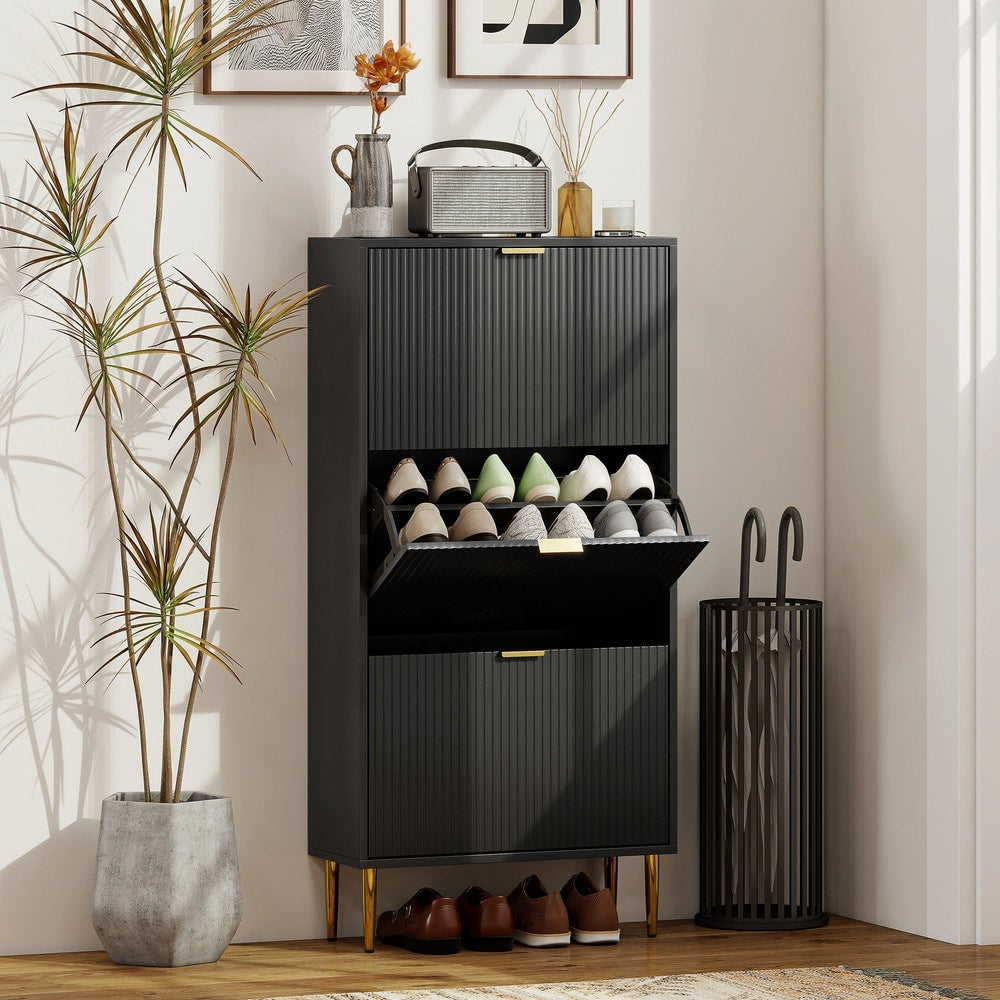 Black three-drawer shoe storage cabinet in a hallway with shoes and umbrella stand