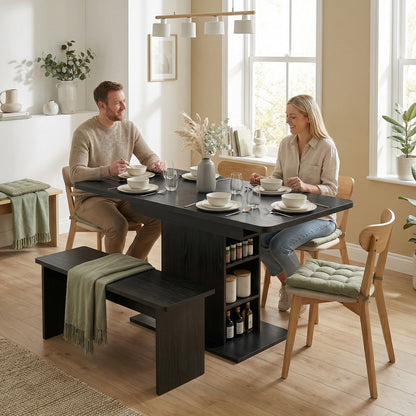 The extendable dining table is set for a meal with two people seated at a bench and two at chairs