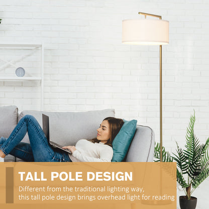 Woman using a laptop next to a tall pole floor lamp in a living room