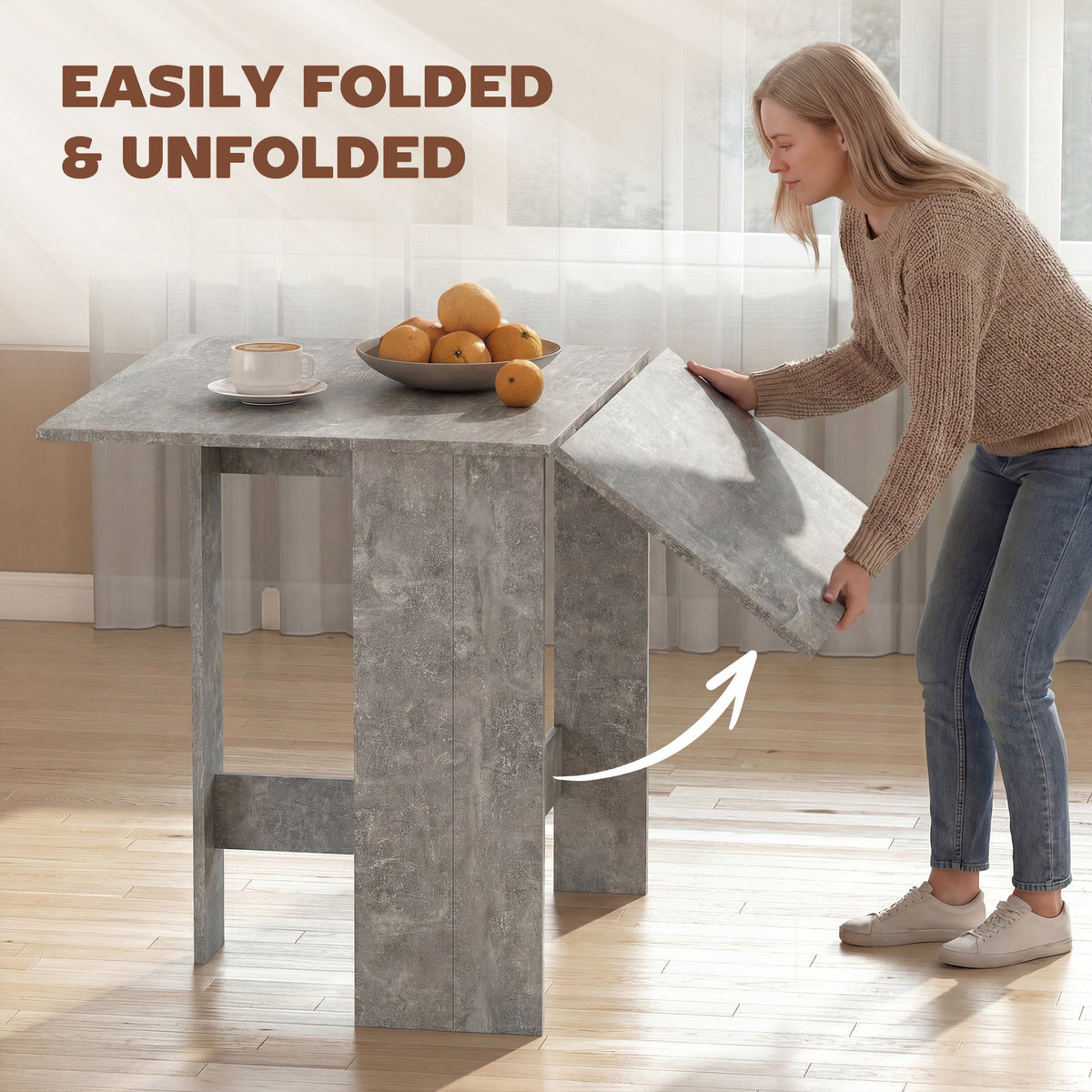 A woman easily folding one leaf of the grey kitchen table